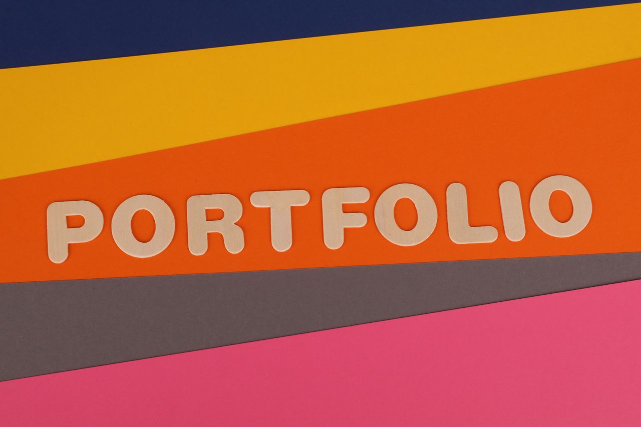 A lively multicolored backdrop displaying the word 'PORTFOLIO' in pink lettering on vibrant paper.